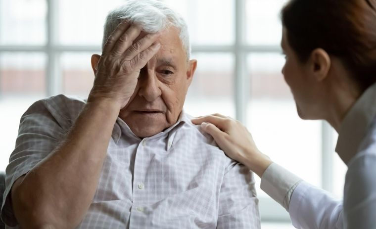 A nurse providing comfort to an elderly man showing memory loss, illustrating a nursing care plan for patient with dementia