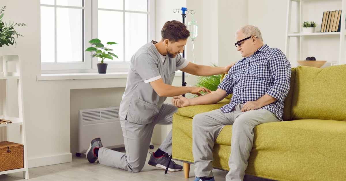 Nurse providing IV Therapy at Home to an elderly man in a comfortable NYC living room setting, ensuring safe and professional infusion care.