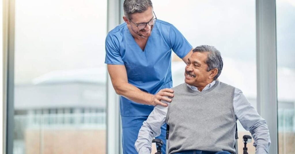 Parkinson’s & Stroke Recovery at Home as a professional caregiver assists an older adult in a wheelchair with daily mobility support in a home setting.