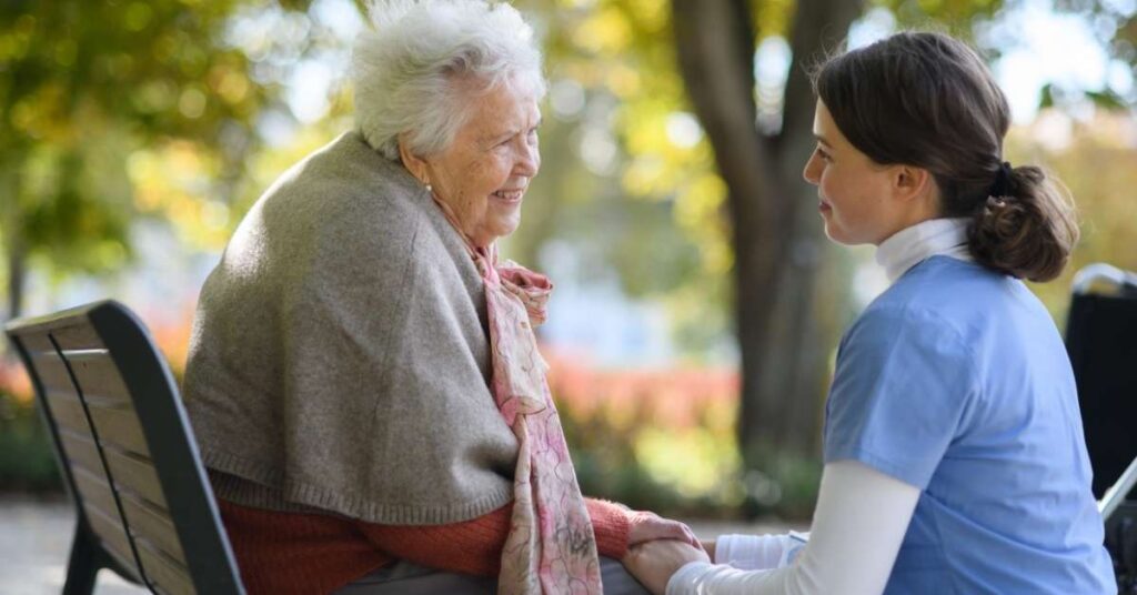 Home health caregiver providing compassionate support to an elderly woman, illustrating palliative care vs hospice care vs home care in a real-life setting.