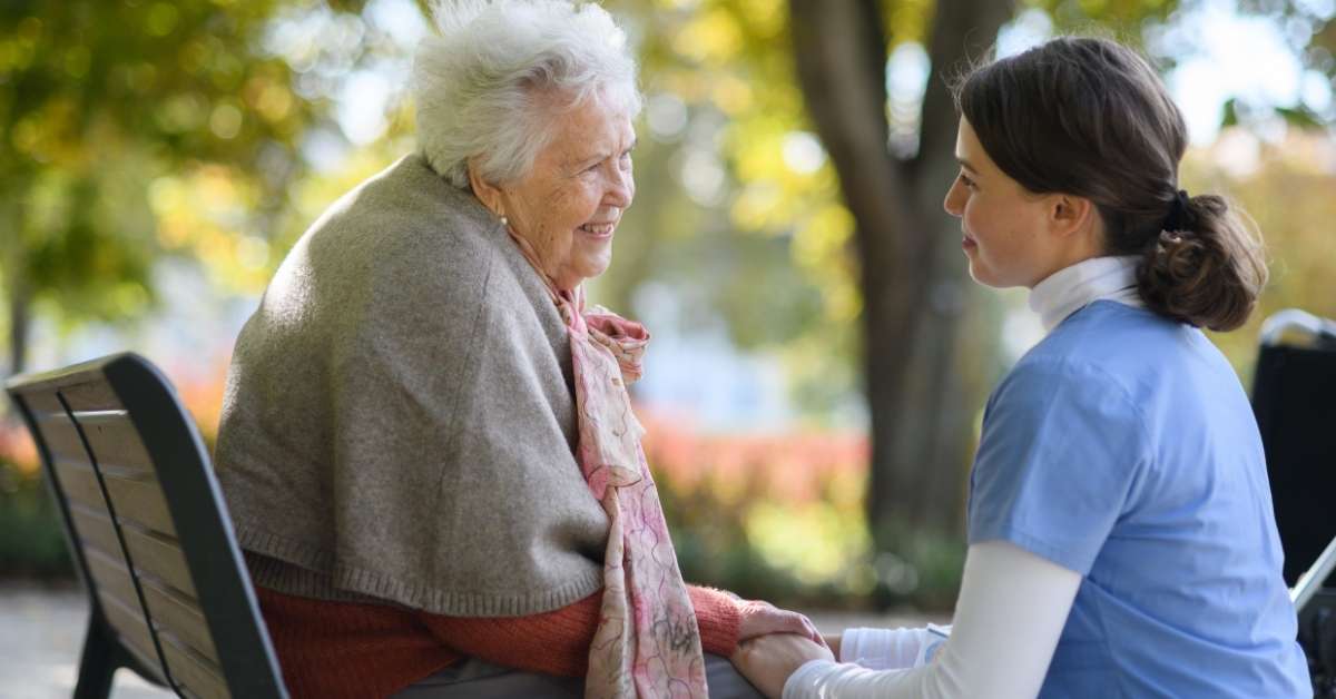 Home health caregiver providing compassionate support to an elderly woman, illustrating palliative care vs hospice care vs home care in a real-life setting.