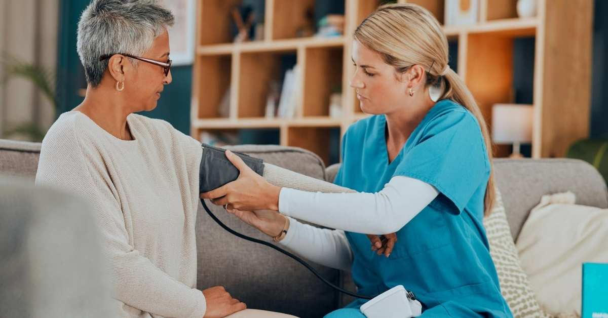 Skilled nursing care nurse checking blood pressure of an elderly woman at home as part of professional home health services.