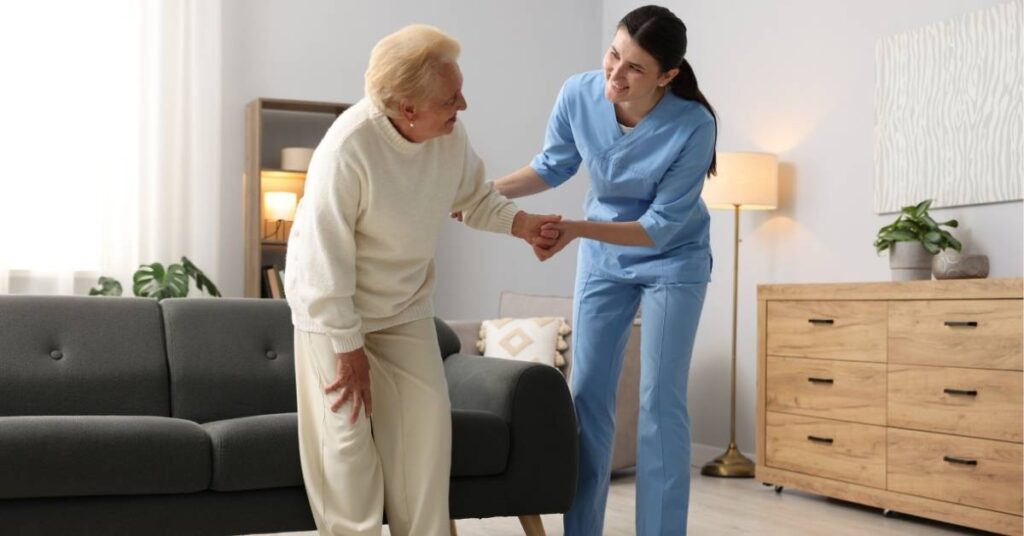 Home health caregiver assisting senior woman with safe mobility at home, highlighting home safety tips for seniors and fall prevention support